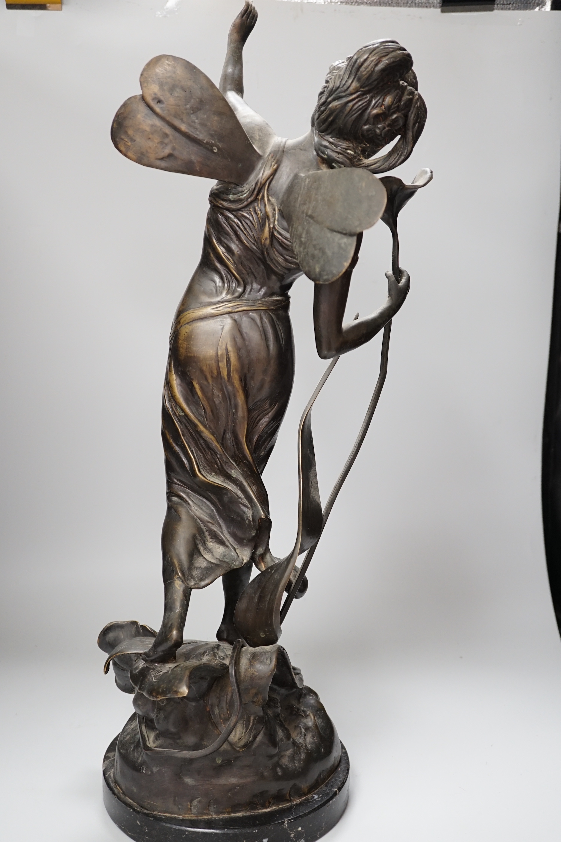 An Art Nouveau style fairy on a black marble base, 63.5cm high